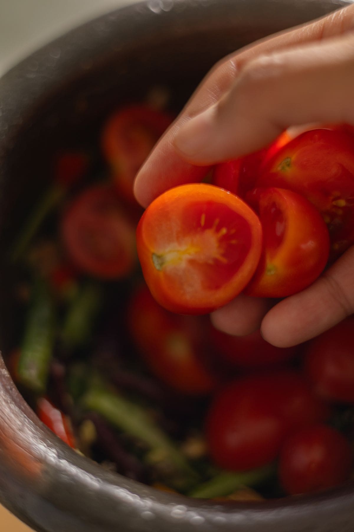 Adding tomatoes to long bean salad